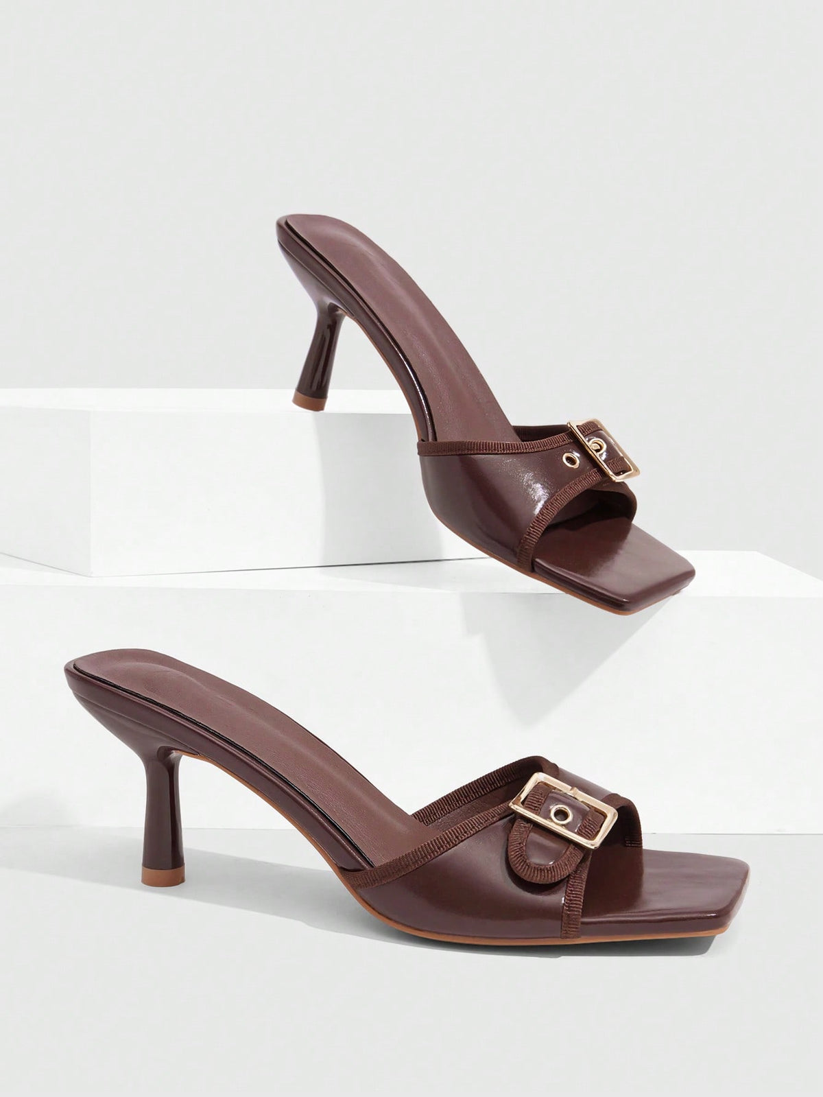 Beige women's slip-on kitten heel slide sandals featuring an accent buckle with grommet eyelets.