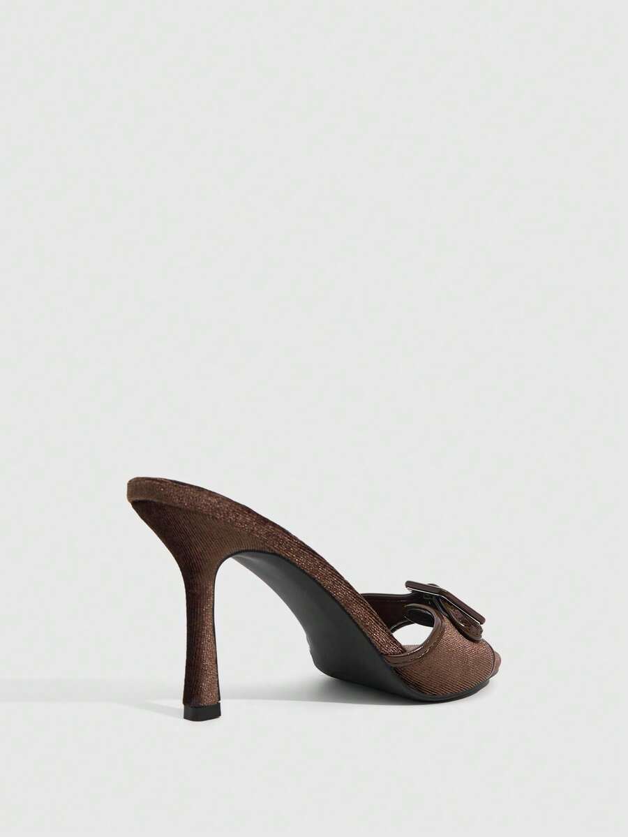 Women's brown leopard print high heel mule sandals with gold-tone buckle and grommet eyelet accents.