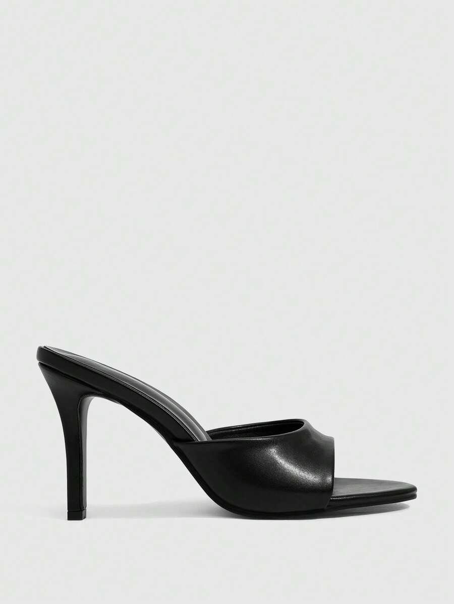 Pair of women's pointed toe stiletto mule sandals with shiny patent upper and slip-on design.