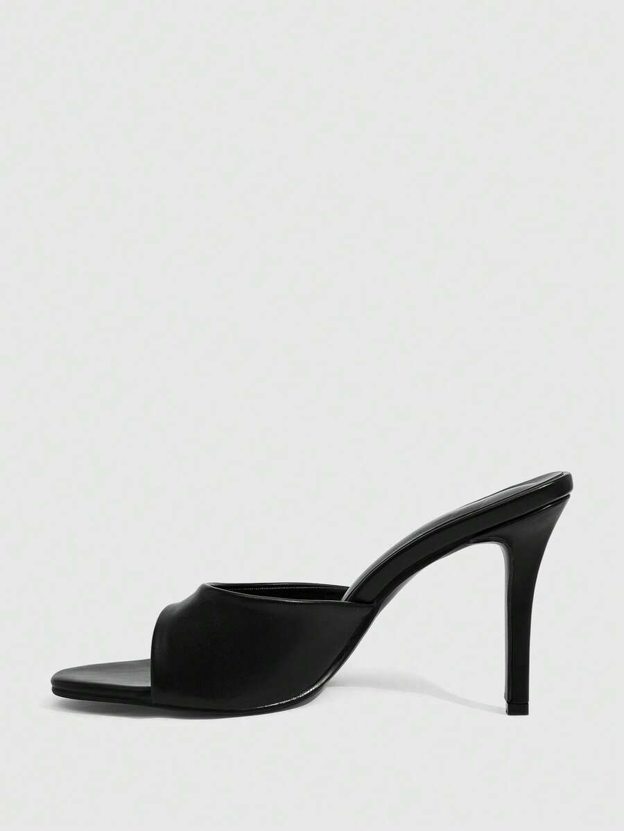 Pair of women's pointed toe stiletto mule sandals with shiny patent upper and slip-on design.