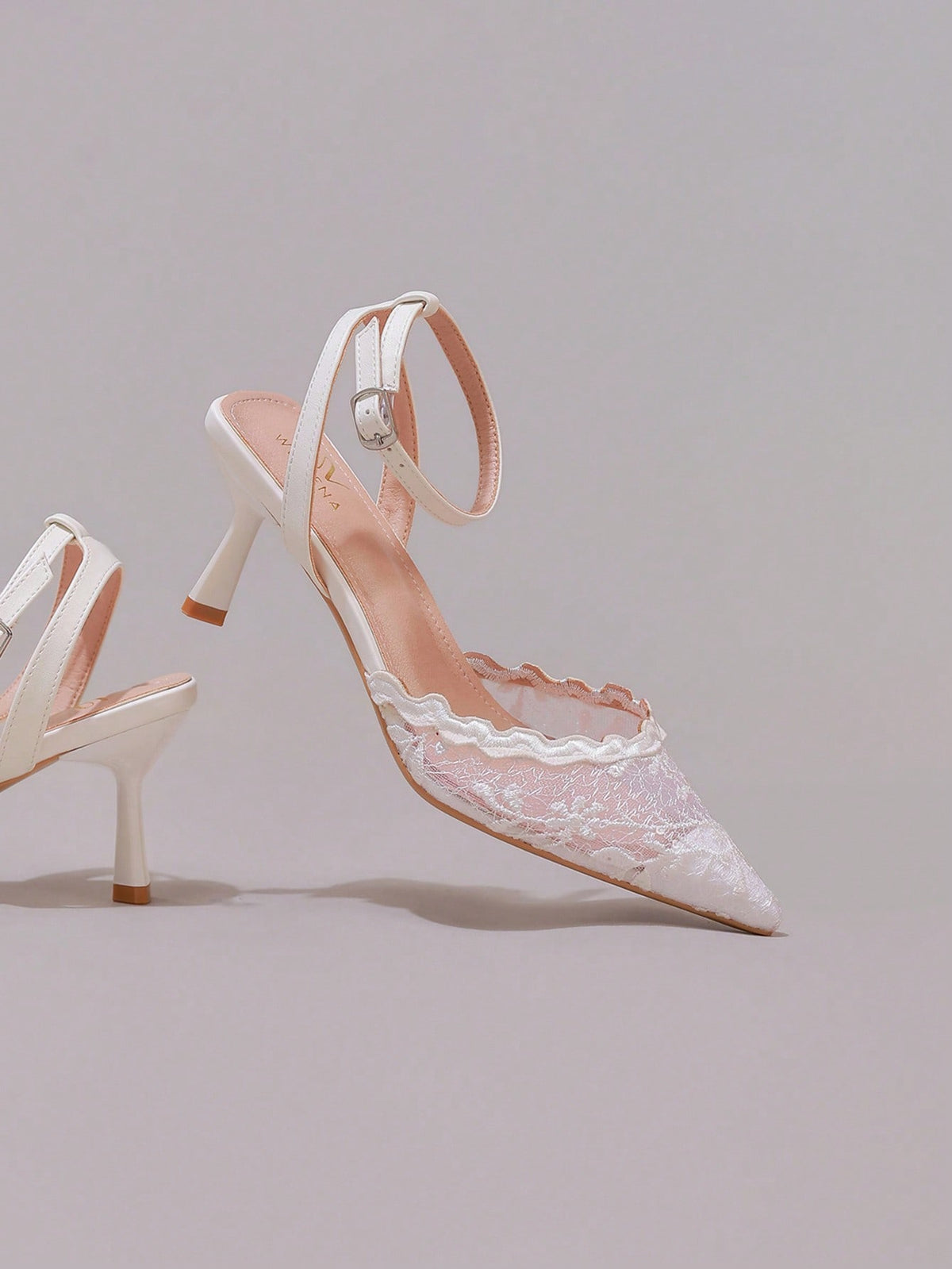 Black lace pointed toe high heel pumps featuring stiletto heels and a decorative bow accent.