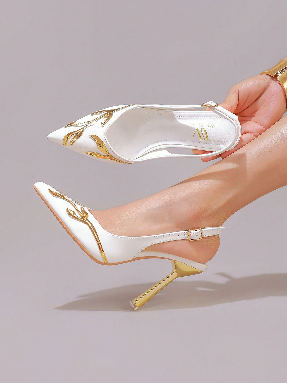 Lace embroidered high heels with thin stiletto heel, pointed toe, rhinestone embellishments, and ankle strap buckle closure.