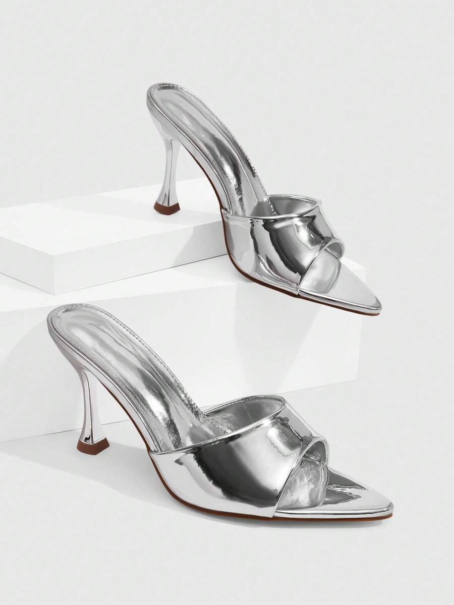 Pair of women's pointed toe stiletto mule sandals with shiny patent upper and slip-on design.