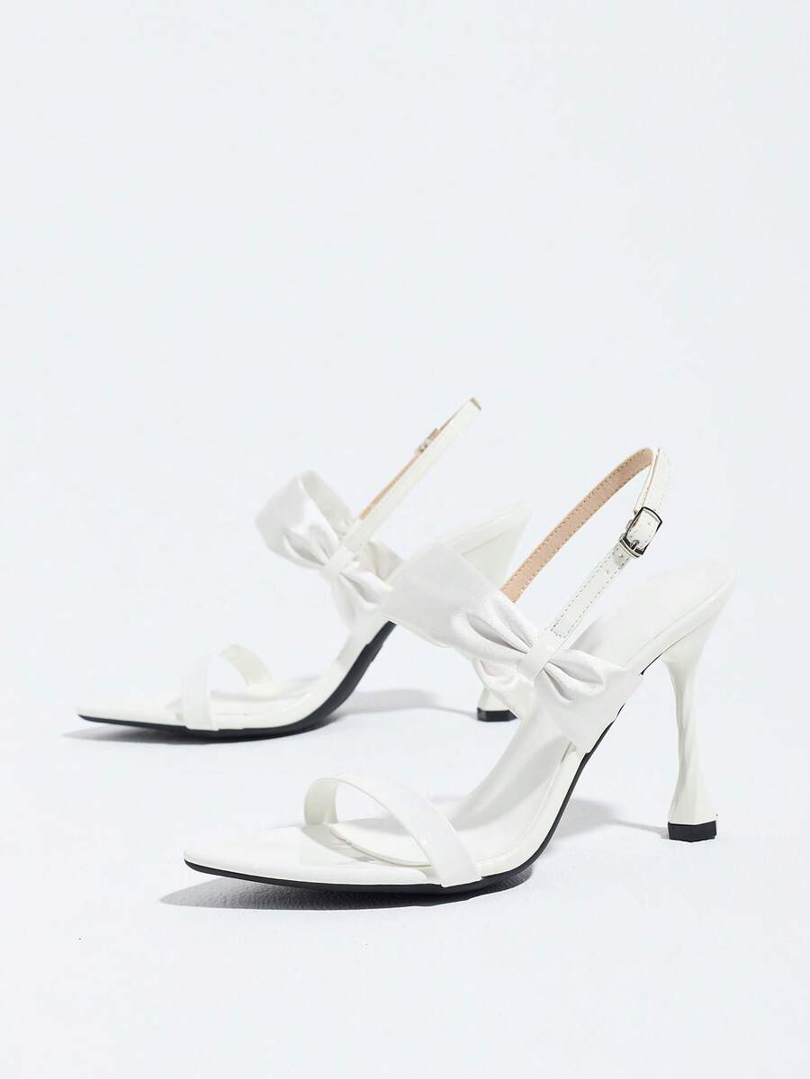 Women's black open toe stiletto heel sandals featuring lace mesh detailing, wide strap styling, and high stiletto heels.