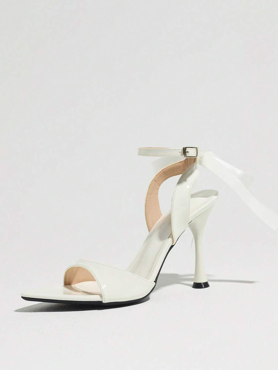 Women's black open toe stiletto heel sandals featuring lace mesh detailing, wide strap styling, and high stiletto heels.
