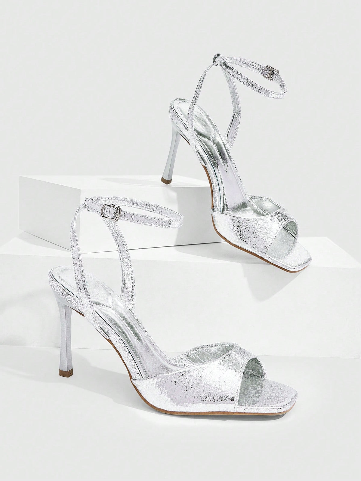 Women's pointed peep toe high heel stilettos featuring cross ankle strap with buckle in black PU leather.