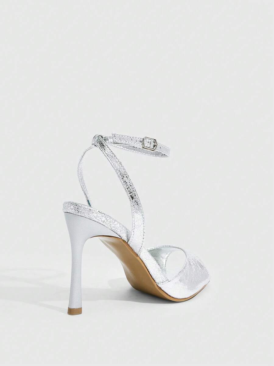 Women's pointed peep toe high heel stilettos featuring cross ankle strap with buckle in black PU leather.