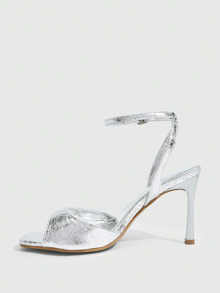 Women's pointed peep toe high heel stilettos featuring cross ankle strap with buckle in black PU leather.