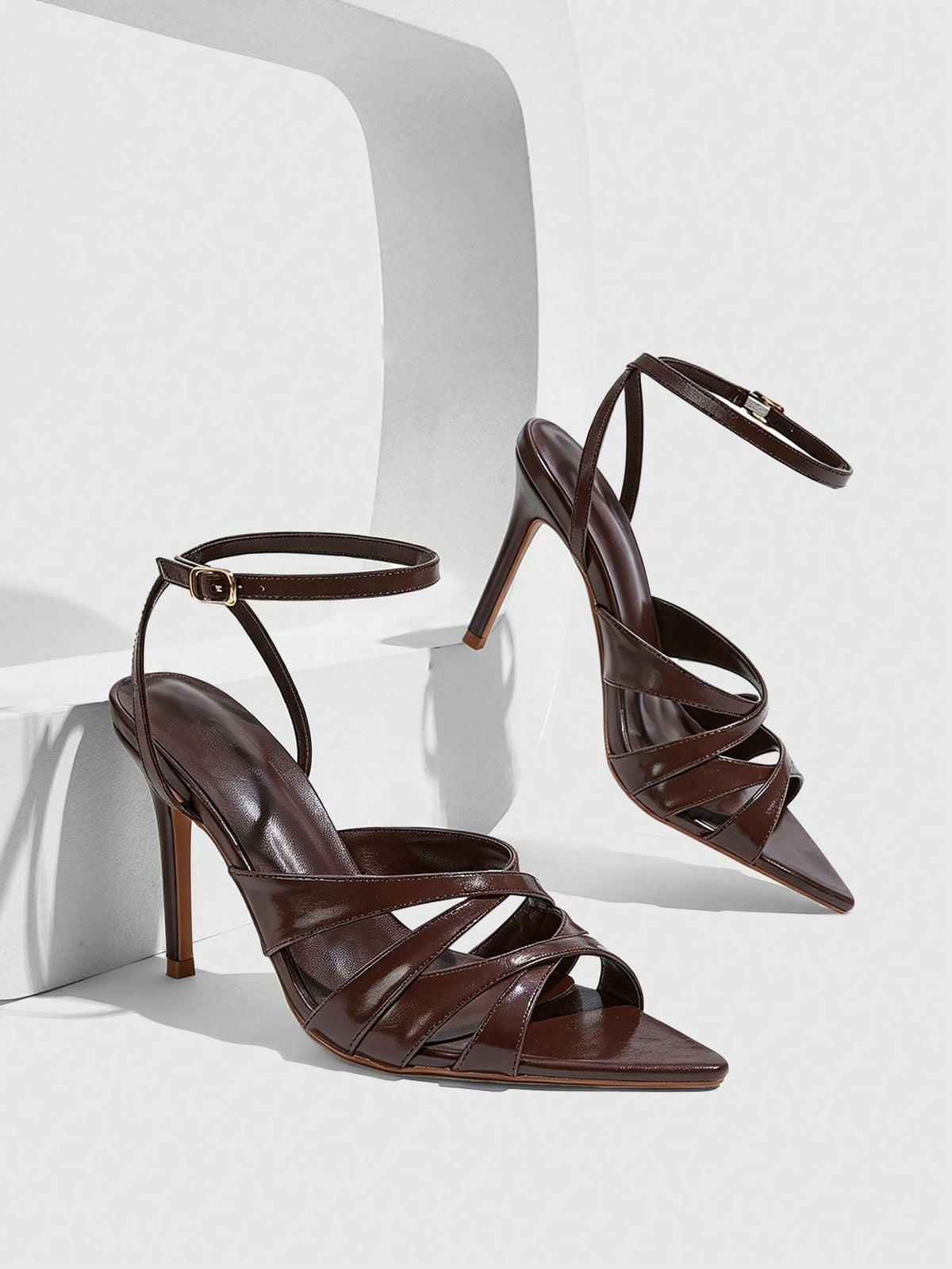Women's open toe high stiletto sandals with cut-out cross straps and adjustable ankle buckle closure.