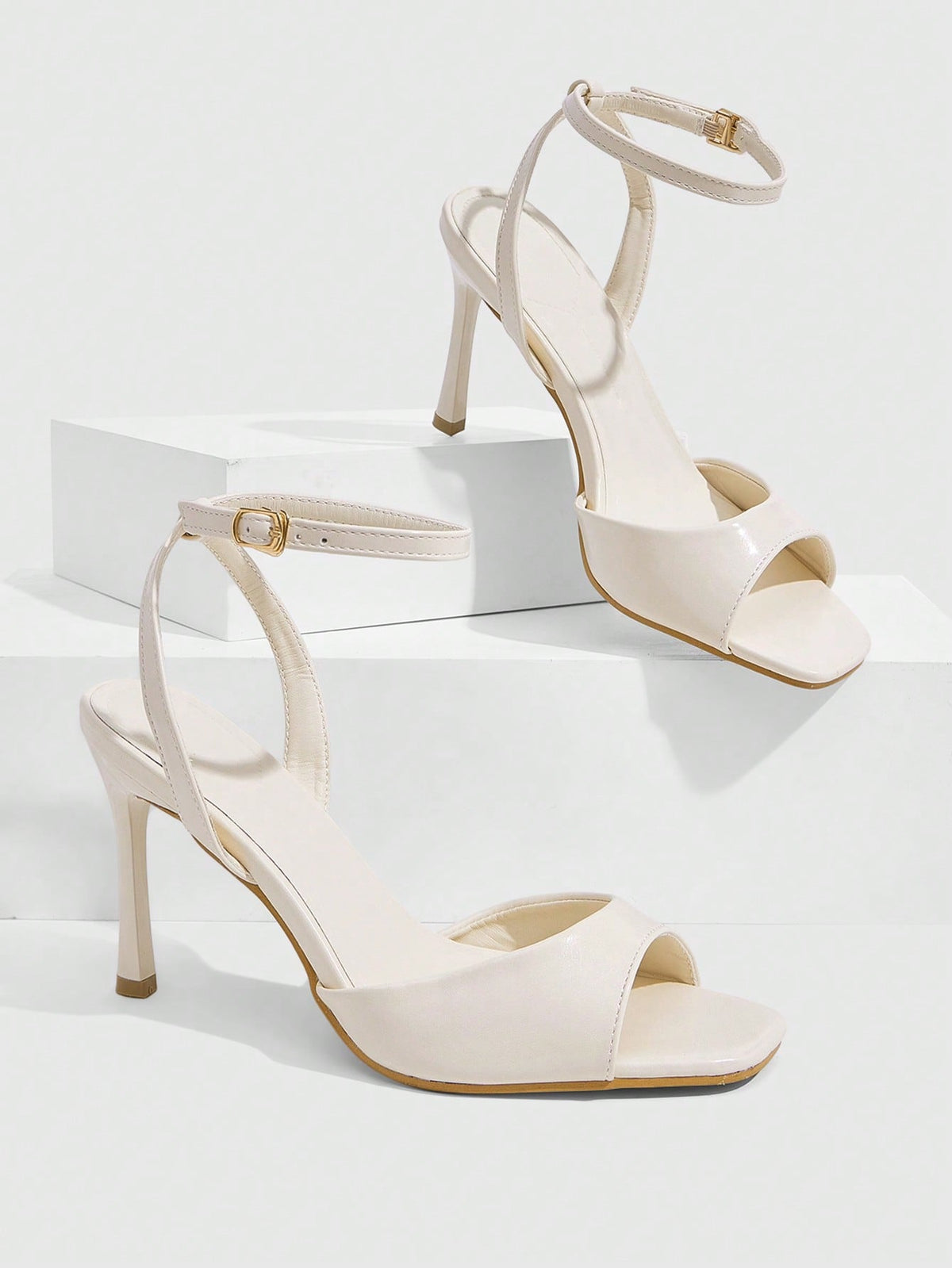 Women's pointed peep toe high heel stilettos featuring cross ankle strap with buckle in black PU leather.