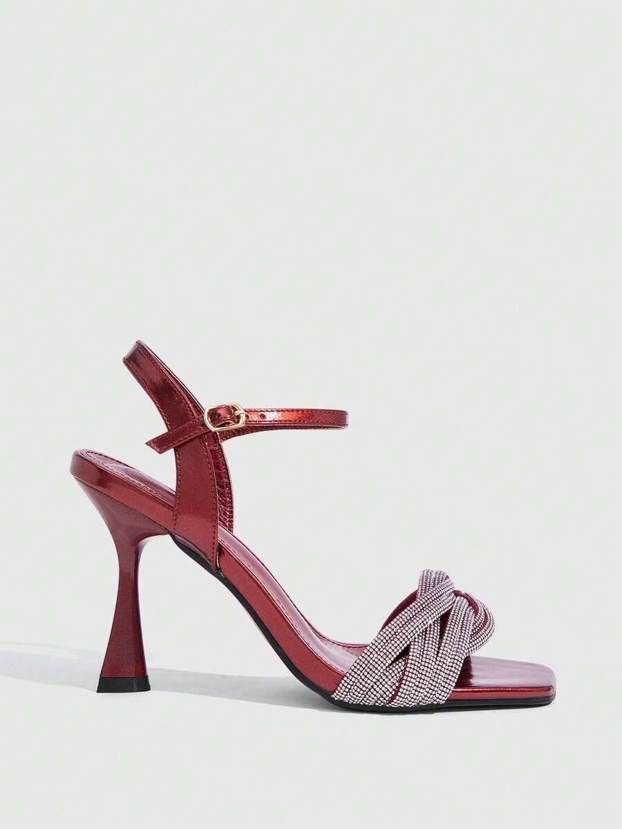 Women's gold open square toe high-heeled sandals featuring a stylish twist strap and stiletto heel.