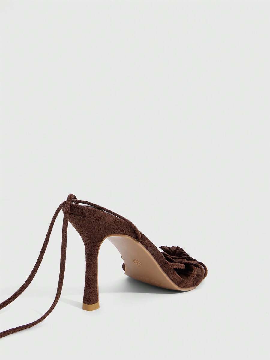 Women's round toe high heel sandals with brown flannel finish, floral trim detail, and strappy lace-up stiletto design.