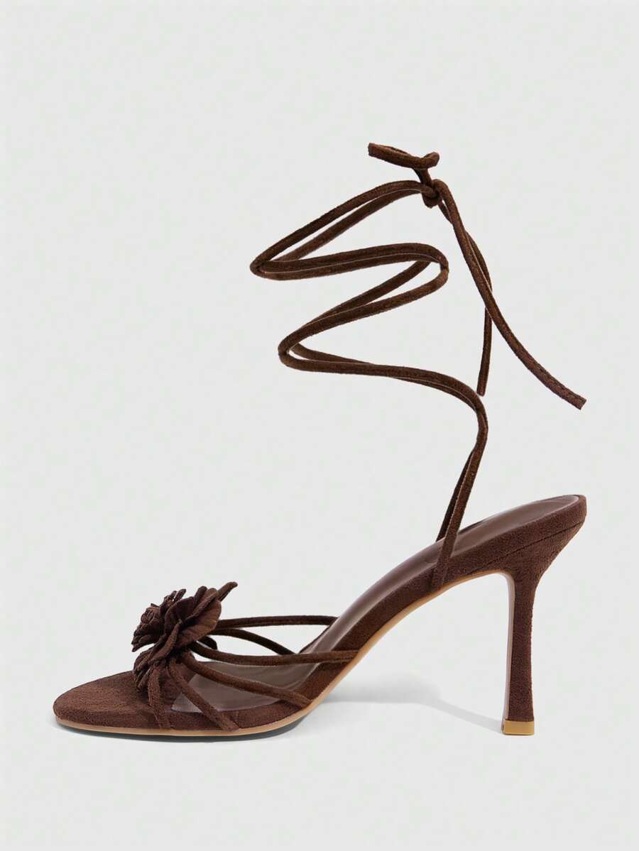 Women's round toe high heel sandals with brown flannel finish, floral trim detail, and strappy lace-up stiletto design.