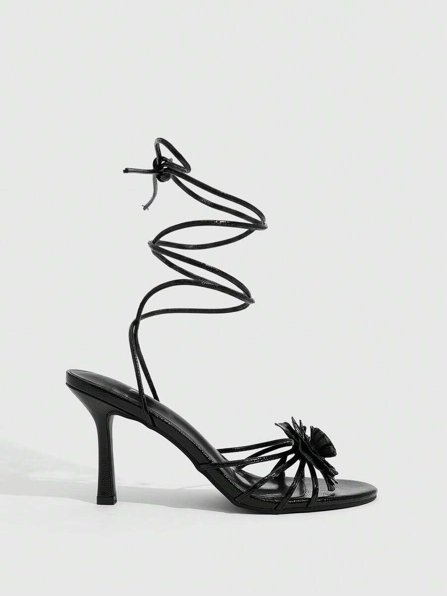 Women's round toe high heel sandals with brown flannel finish, floral trim detail, and strappy lace-up stiletto design.