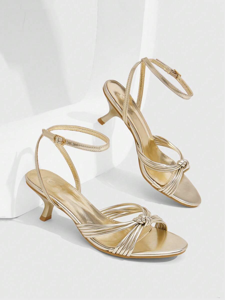 Women's champagne stiletto high heel sandals featuring knotted cross-over straps, open round toe, and adjustable ankle buckle strap.