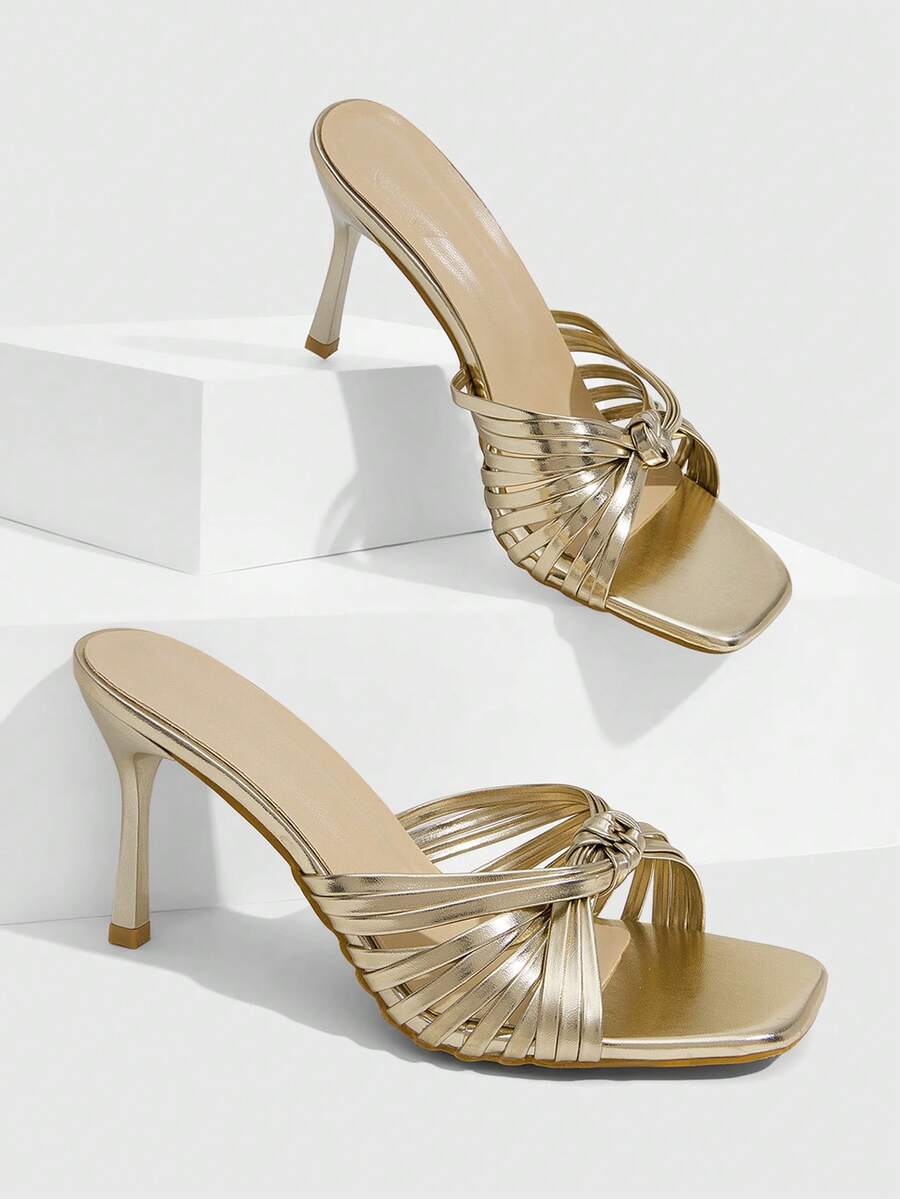 Women's champagne stiletto high heel sandals featuring knotted cross-over straps, open round toe, and adjustable ankle buckle strap.