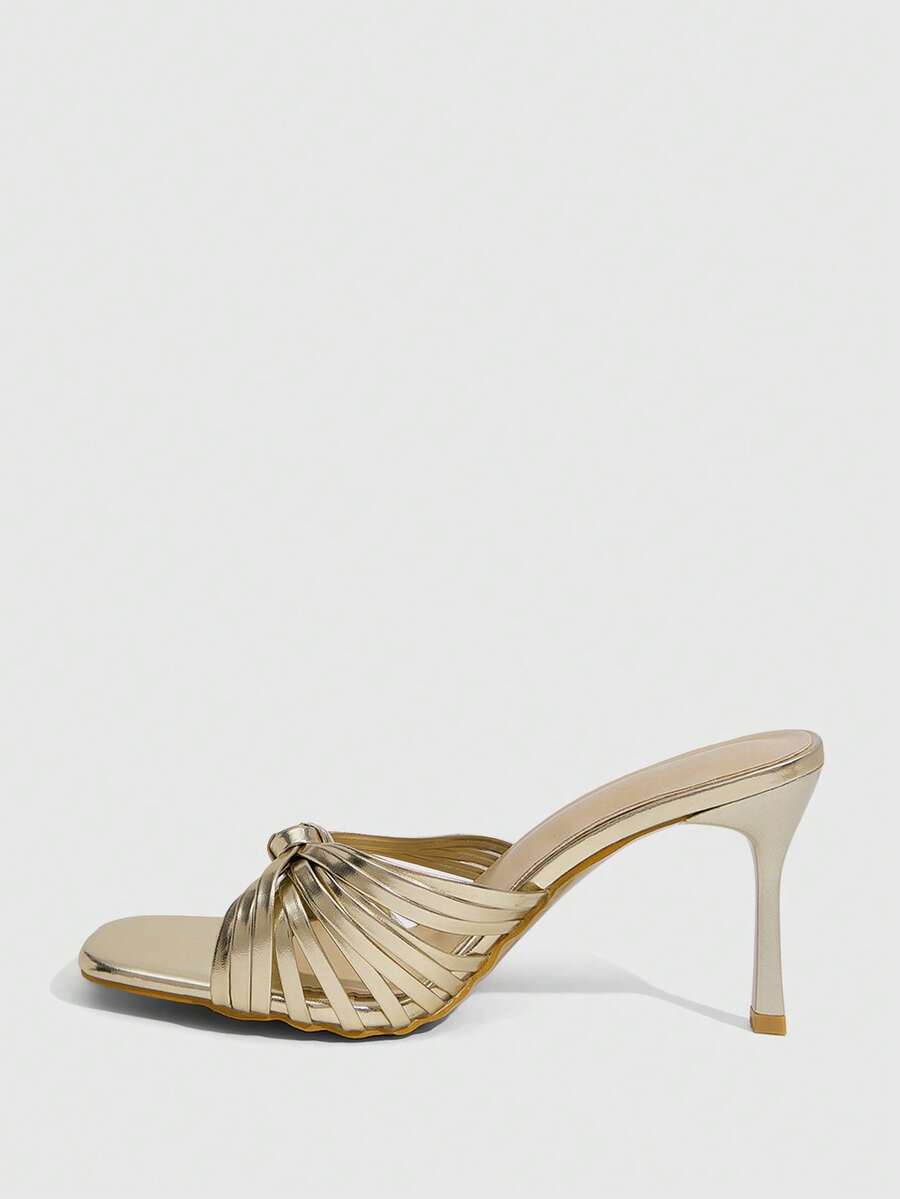 Women's champagne stiletto high heel sandals featuring knotted cross-over straps, open round toe, and adjustable ankle buckle strap.