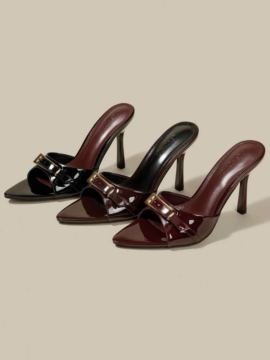 Black patent leather pointed toe mule sandals featuring stiletto high heels and decorative buckle detail for evening parties