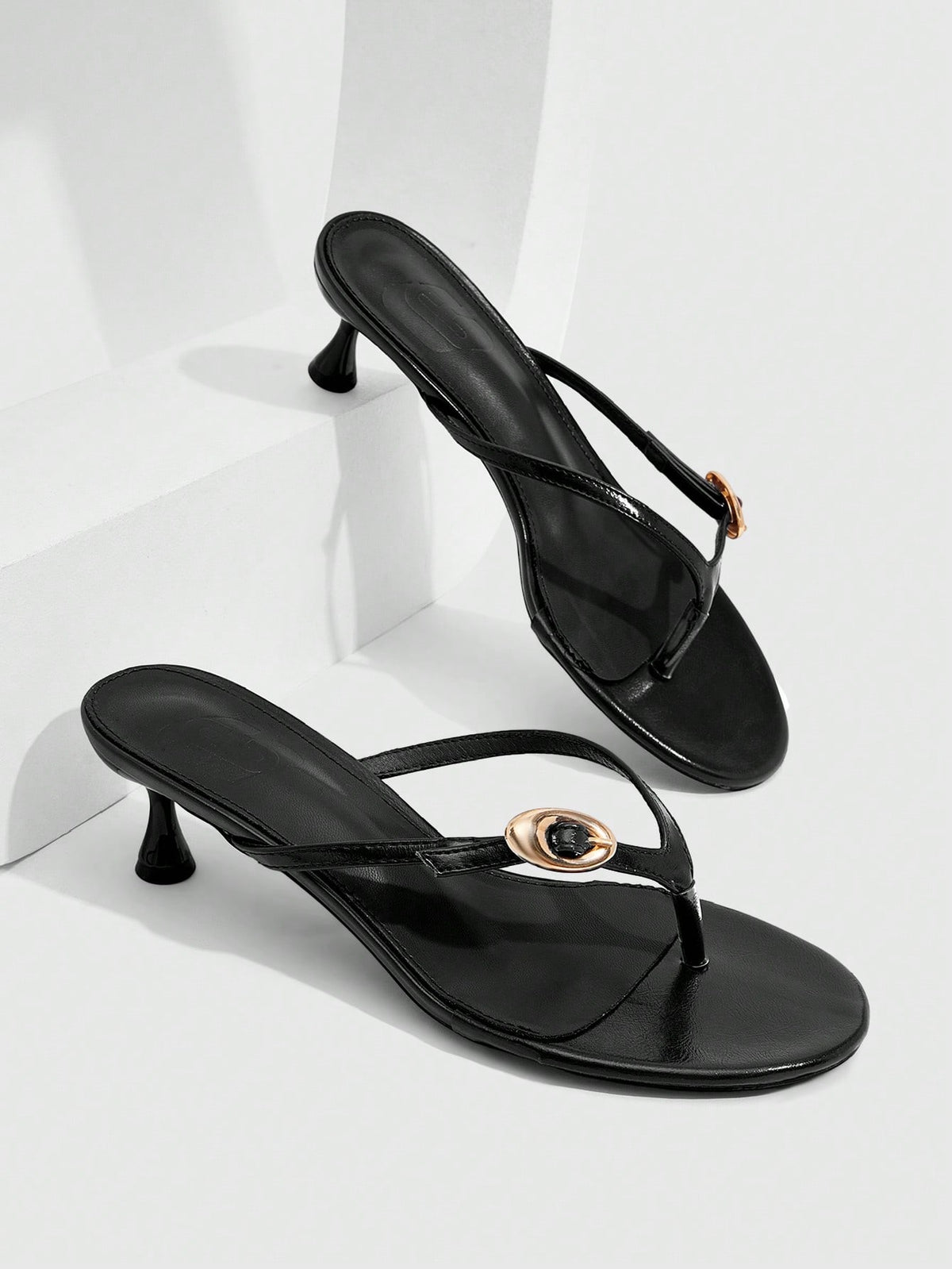 Women's slingback heeled sandals featuring a button toe post accent, sleek mid pyramid heel, and smooth faux leather finish.