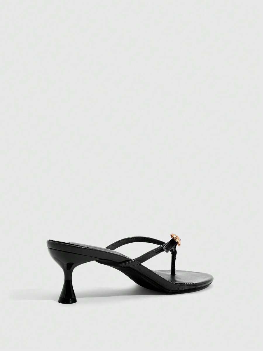 Women's slingback heeled sandals featuring a button toe post accent, sleek mid pyramid heel, and smooth faux leather finish.