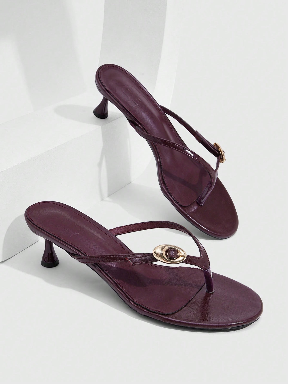 Women's slingback heeled sandals featuring a button toe post accent, sleek mid pyramid heel, and smooth faux leather finish.