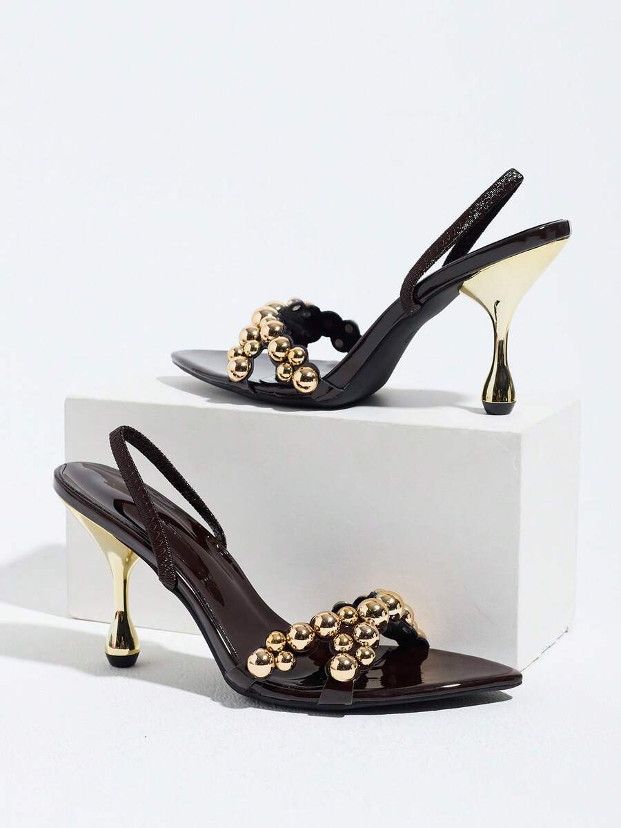 Pointed toe party high heels in gold featuring wavy lace trim, a stiletto heel, and back tie slingback straps.