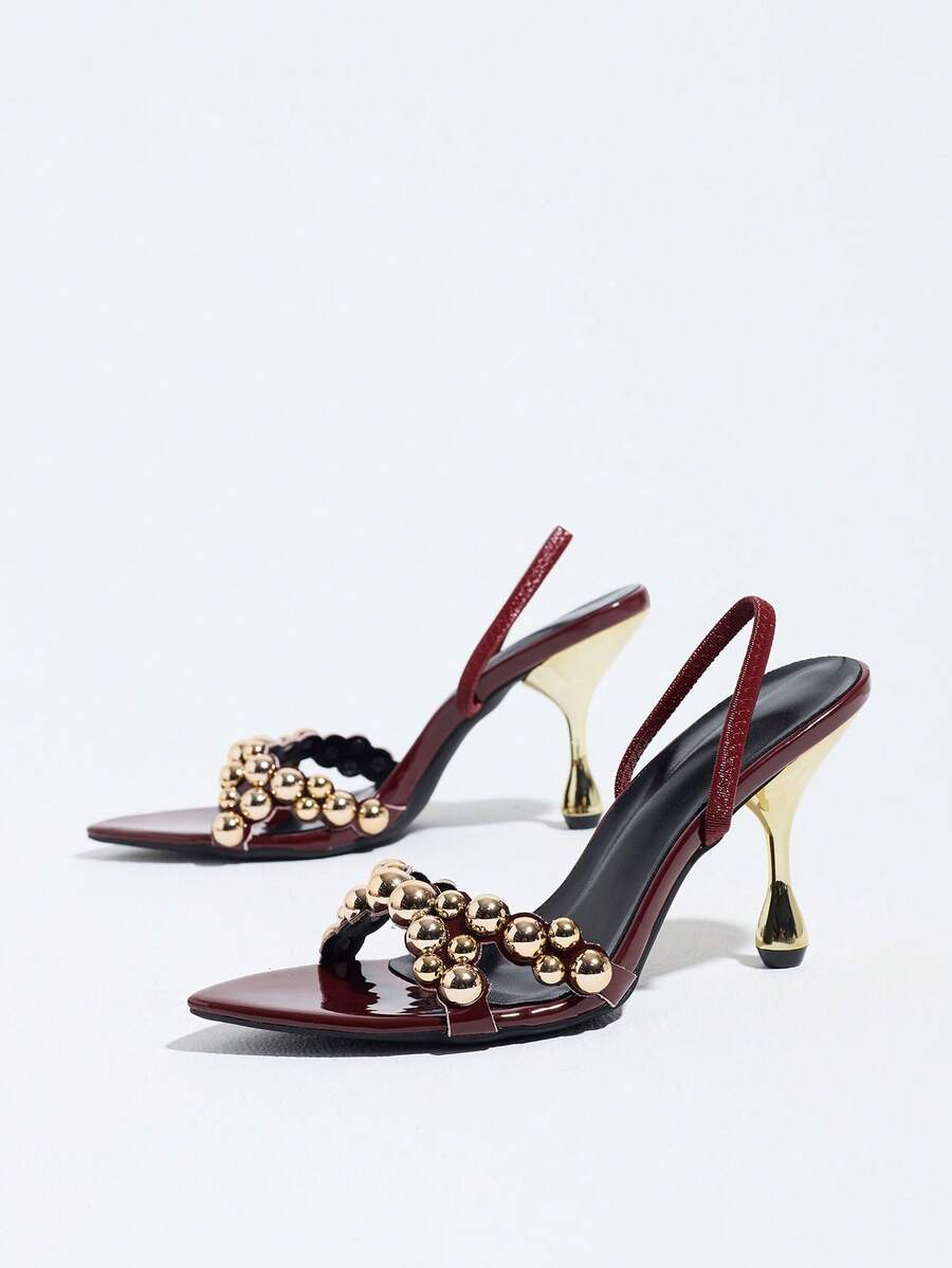 Pointed toe party high heels in gold featuring wavy lace trim, a stiletto heel, and back tie slingback straps.