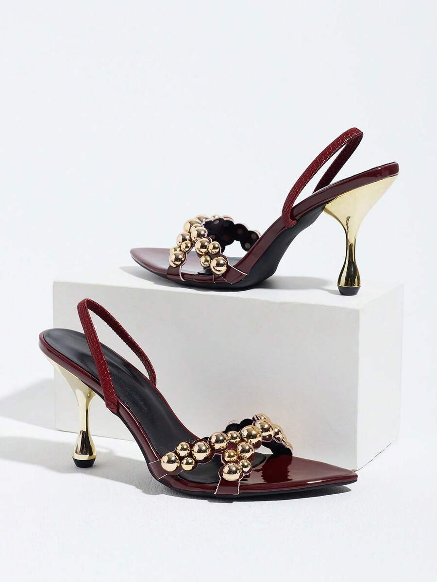 Pointed toe party high heels in gold featuring wavy lace trim, a stiletto heel, and back tie slingback straps.