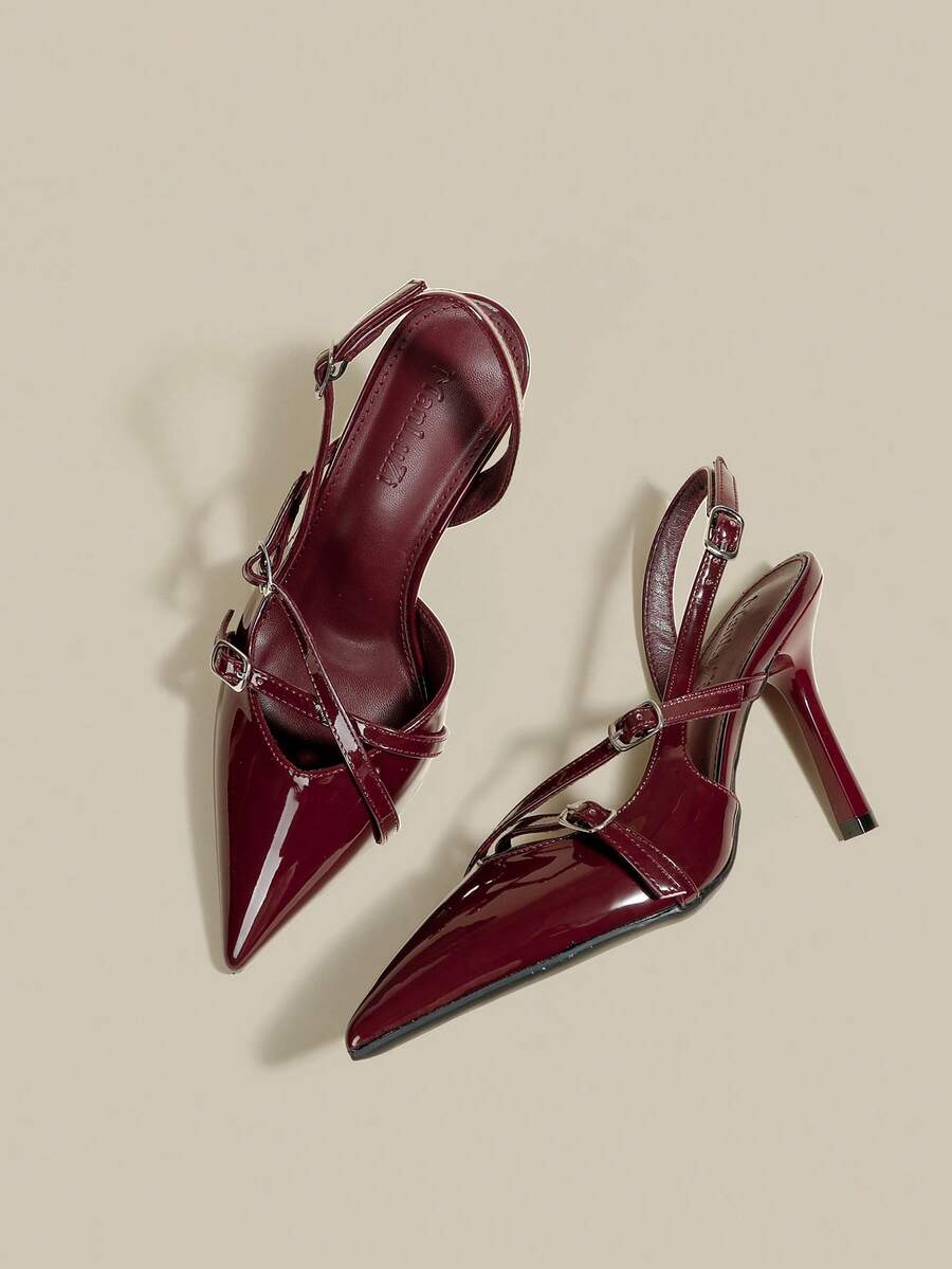 Women's pointed toe kitten heel pumps with adjustable buckle back strap and sleek patent finish.