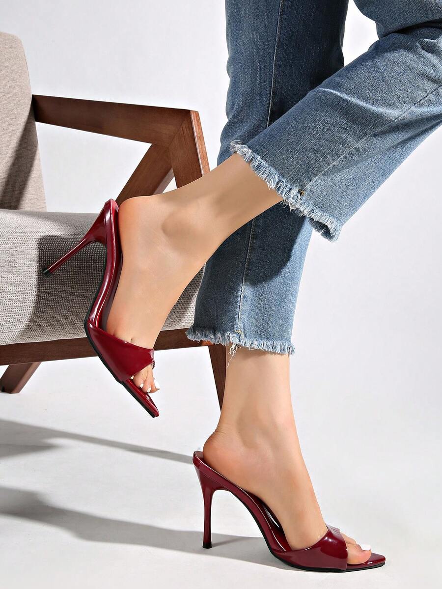 Patent leather open toe slingback slide sandals with stiletto high heels and slip on design.