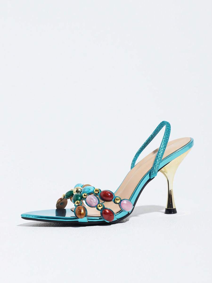 Pointed toe party high heels in gold featuring wavy lace trim, a stiletto heel, and back tie slingback straps.