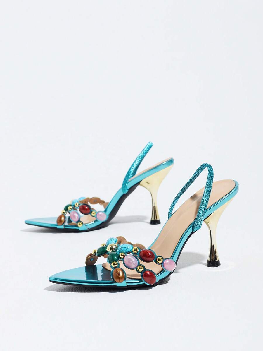 Pointed toe party high heels in gold featuring wavy lace trim, a stiletto heel, and back tie slingback straps.