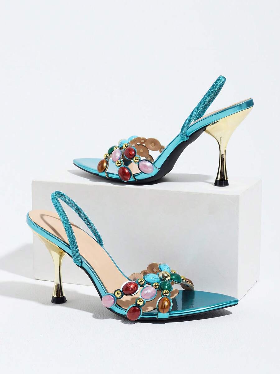 Pointed toe party high heels in gold featuring wavy lace trim, a stiletto heel, and back tie slingback straps.