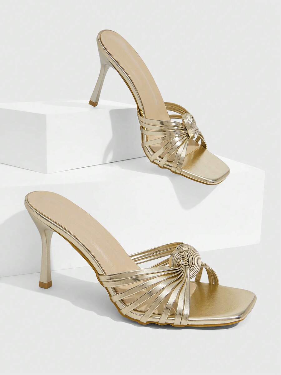 Women's gold open square toe high-heeled sandals featuring a stylish twist strap and stiletto heel.