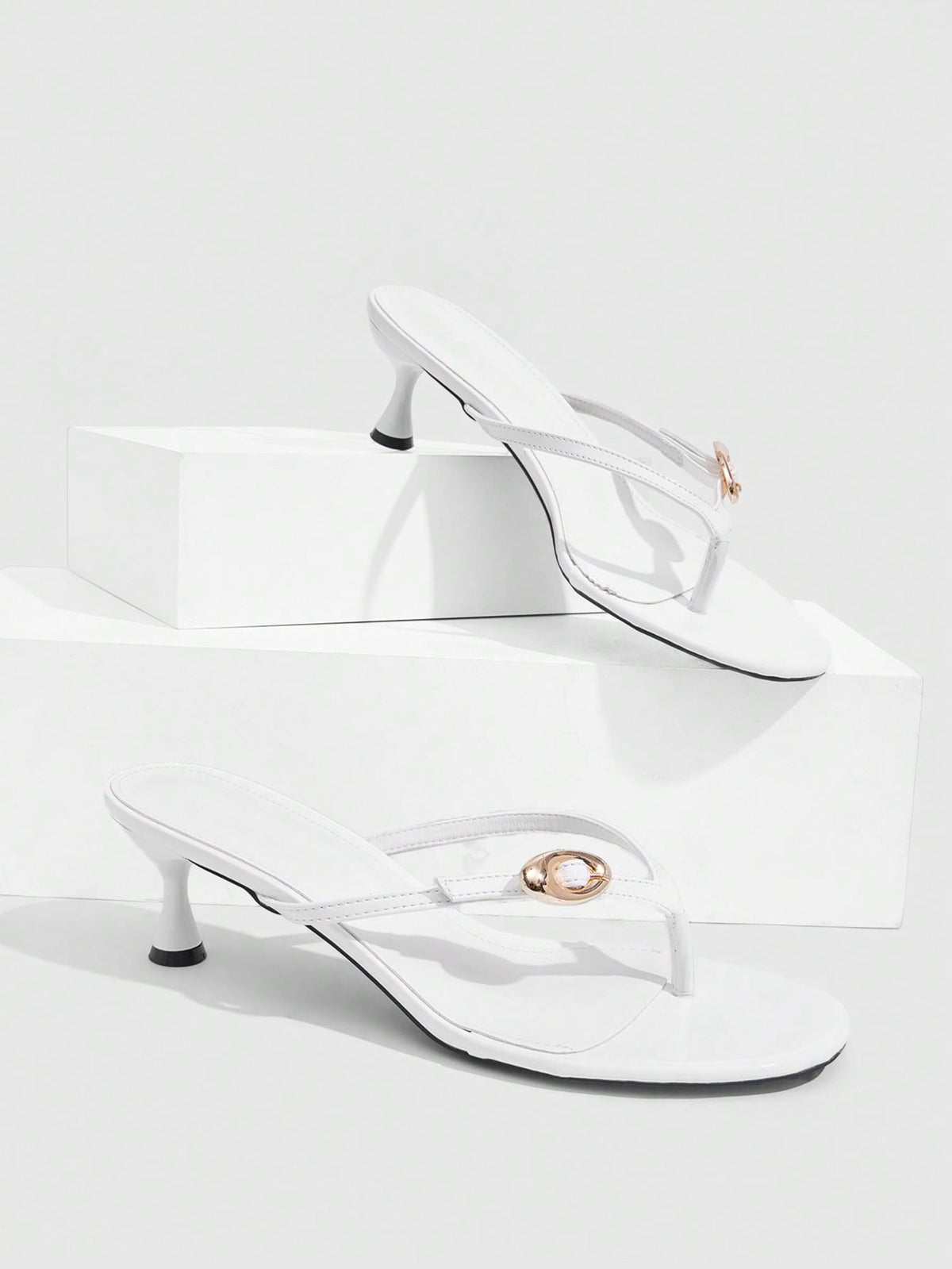 Women's slingback heeled sandals featuring a button toe post accent, sleek mid pyramid heel, and smooth faux leather finish.