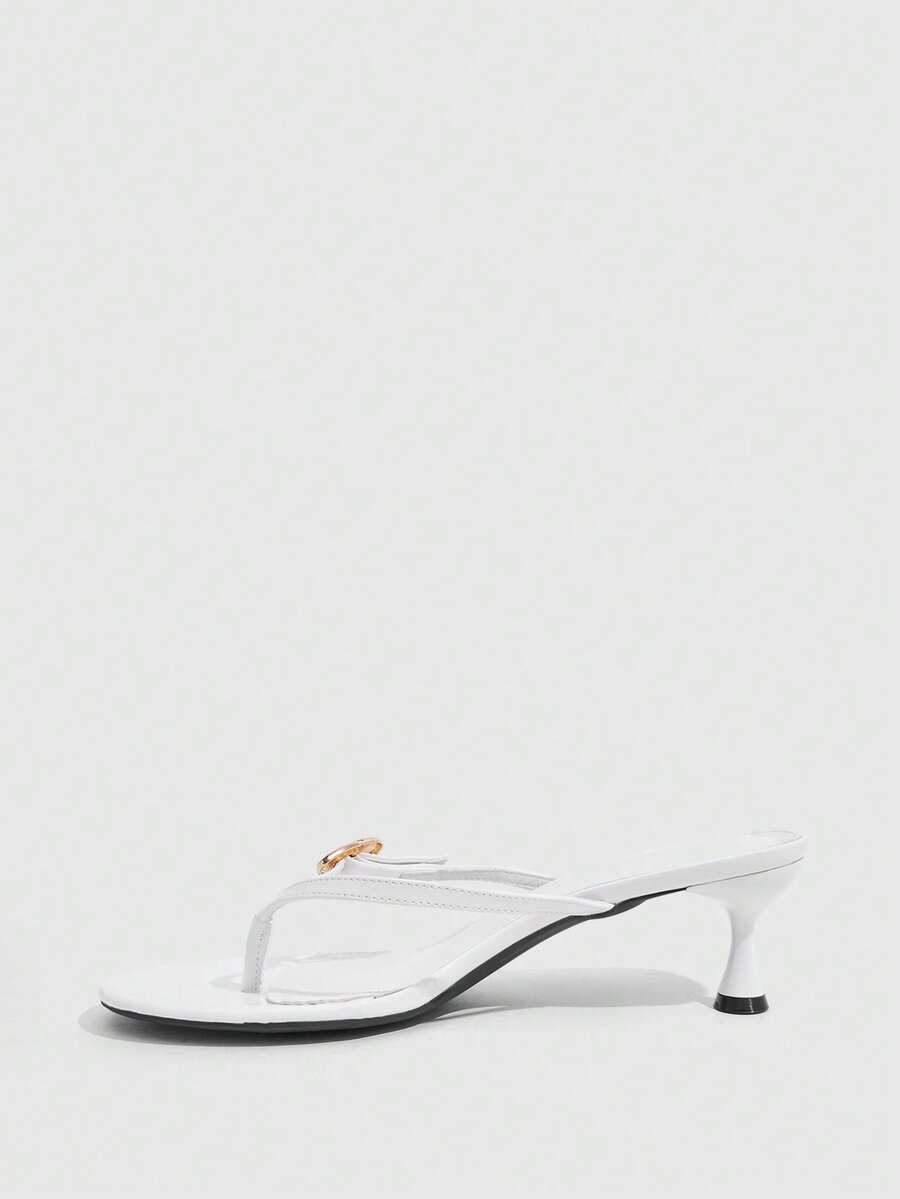 Women's slingback heeled sandals featuring a button toe post accent, sleek mid pyramid heel, and smooth faux leather finish.