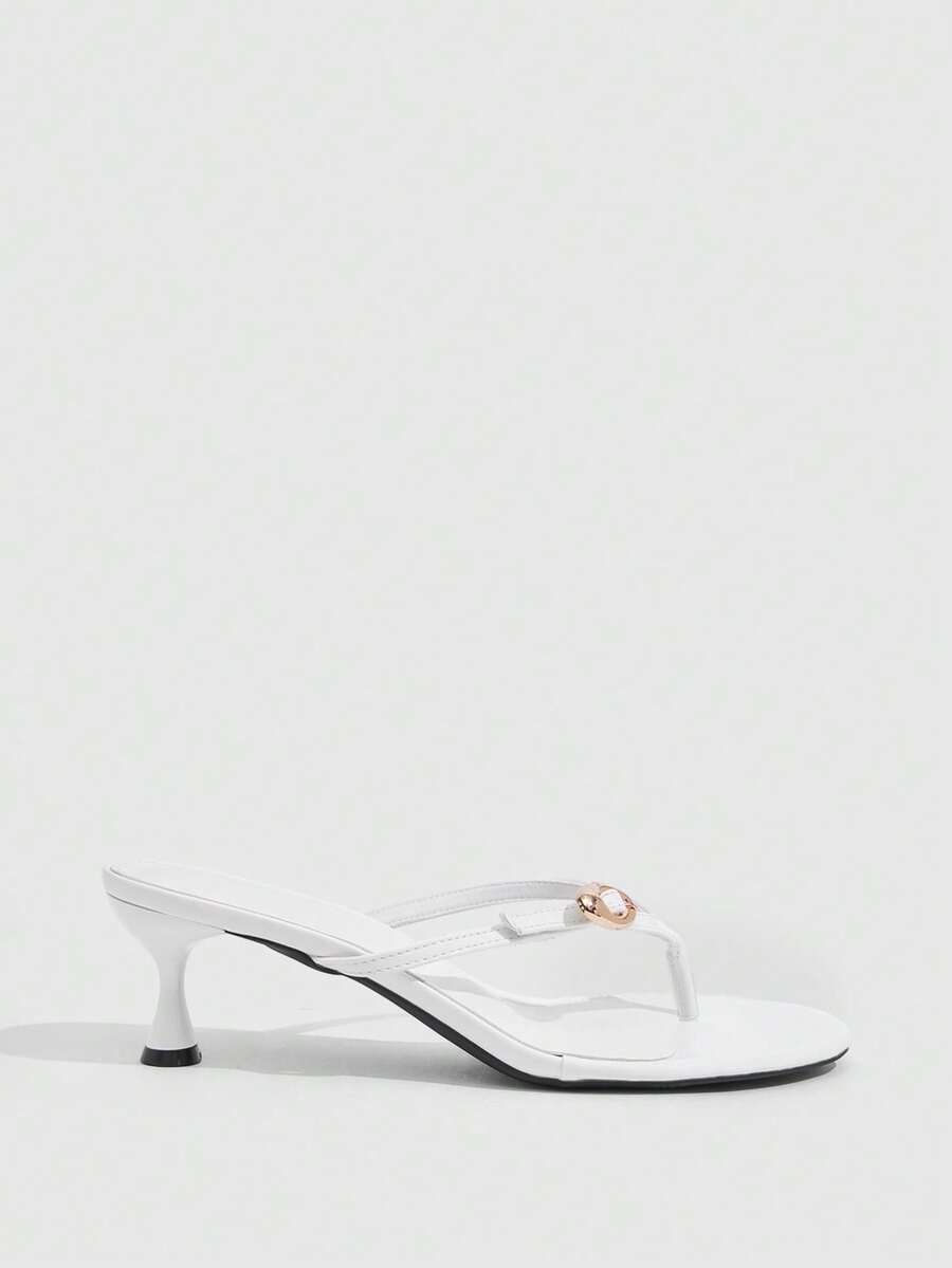 Women's slingback heeled sandals featuring a button toe post accent, sleek mid pyramid heel, and smooth faux leather finish.