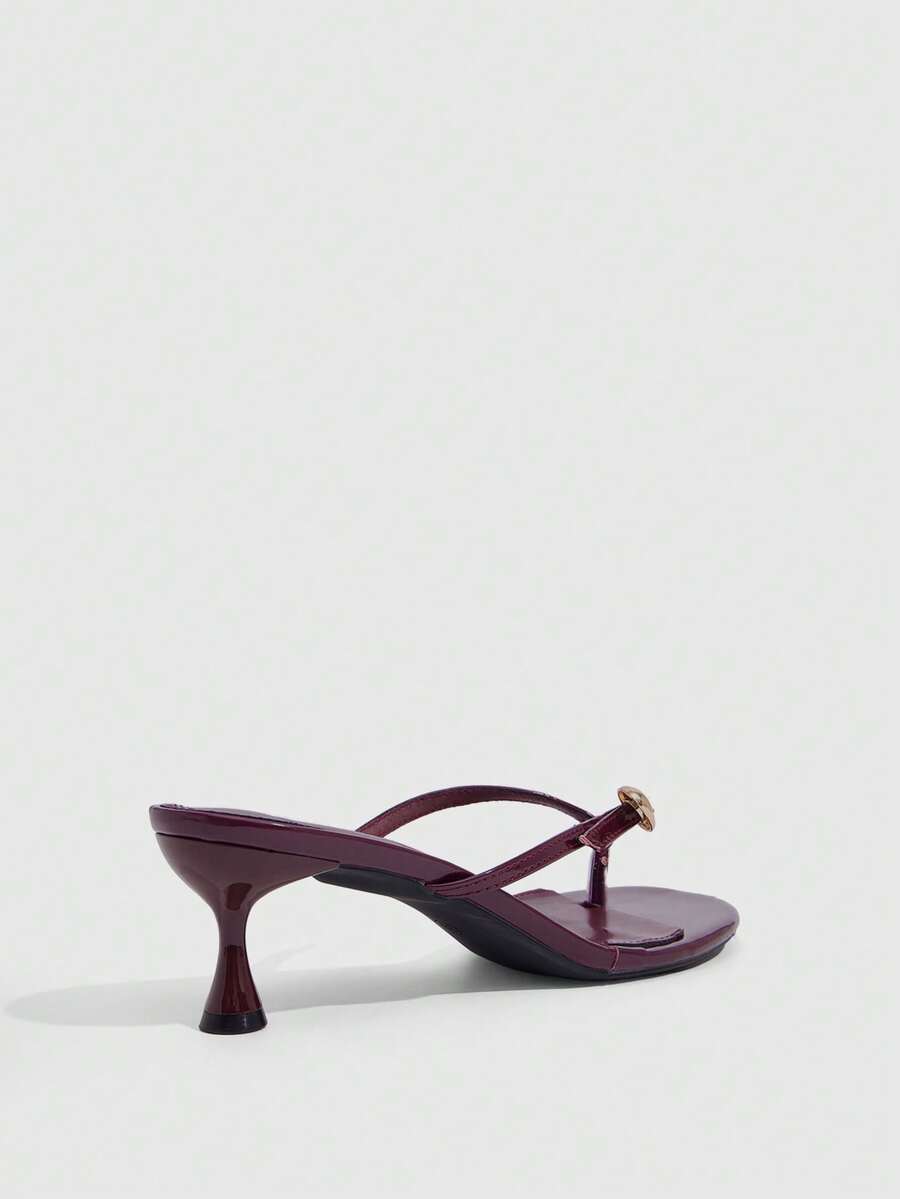 Women's slingback heeled sandals featuring a button toe post accent, sleek mid pyramid heel, and smooth faux leather finish.