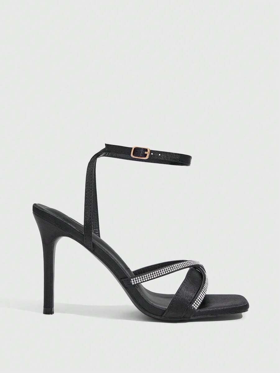 Women's pointed peep toe high heel stilettos featuring cross ankle strap with buckle in black PU leather.