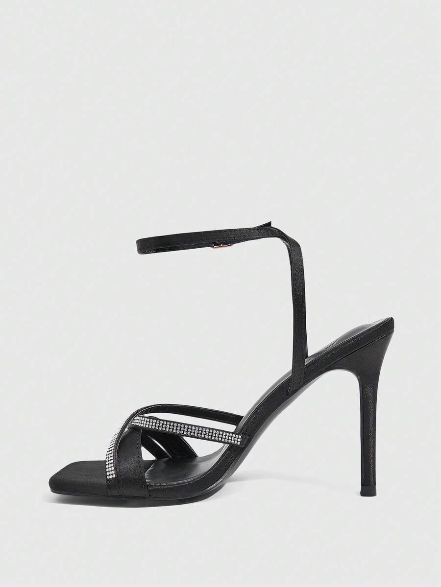 Women's pointed peep toe high heel stilettos featuring cross ankle strap with buckle in black PU leather.