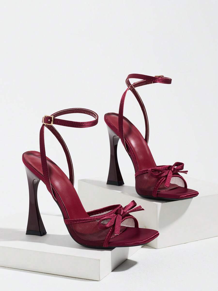 Burgundy women's square toe high heel sandals featuring a mesh bow accent and ankle strap buckle on an open toe silhouette