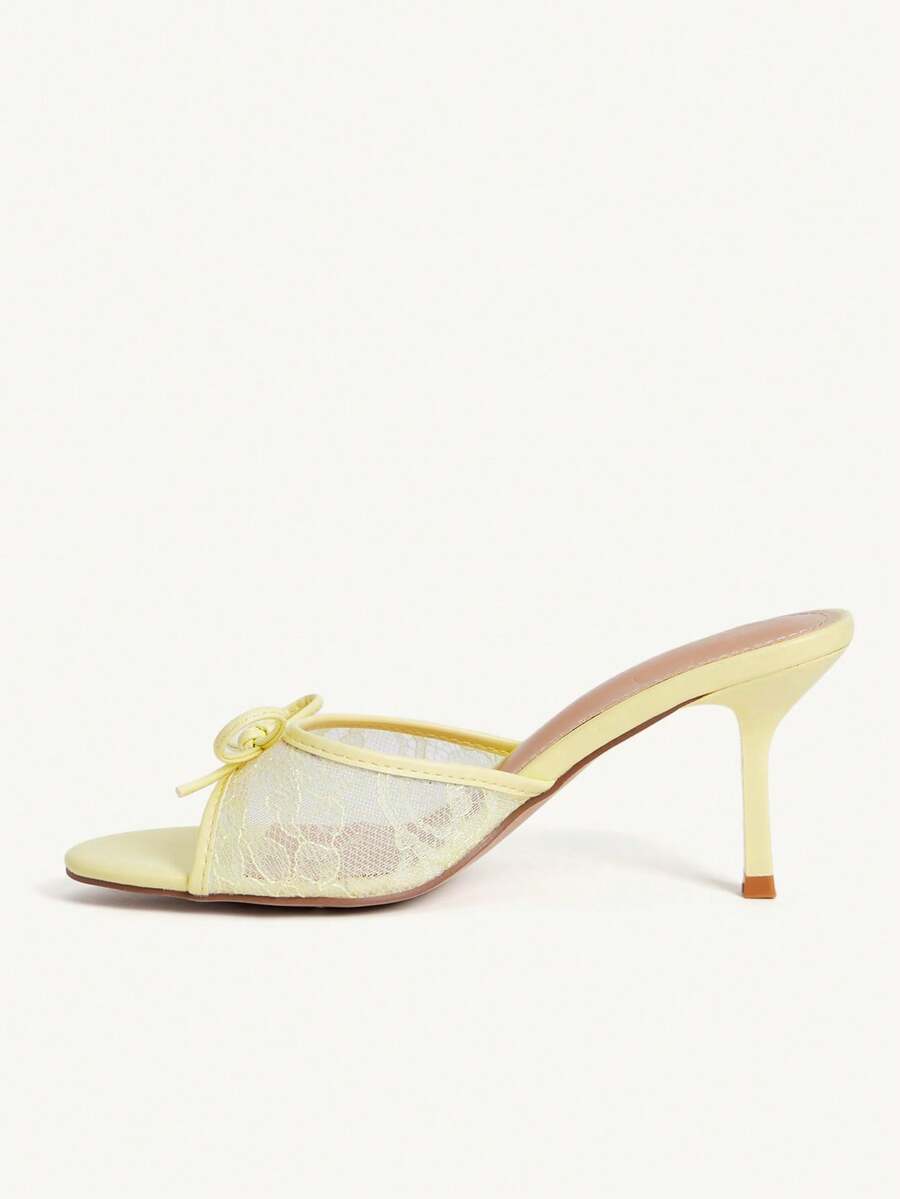 Open toe high heel slide sandals featuring lace details and a bow accent on the upper strap.