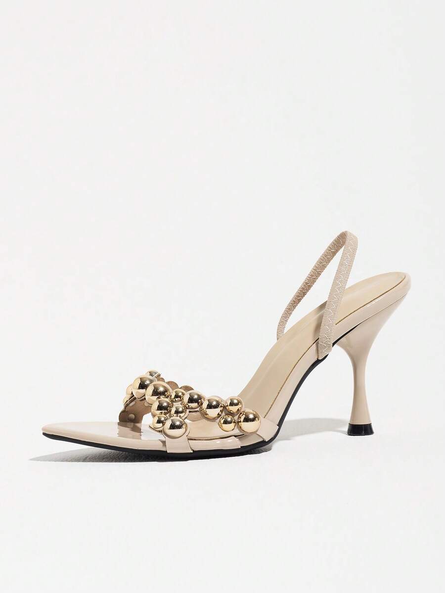 Pointed toe party high heels in gold featuring wavy lace trim, a stiletto heel, and back tie slingback straps.