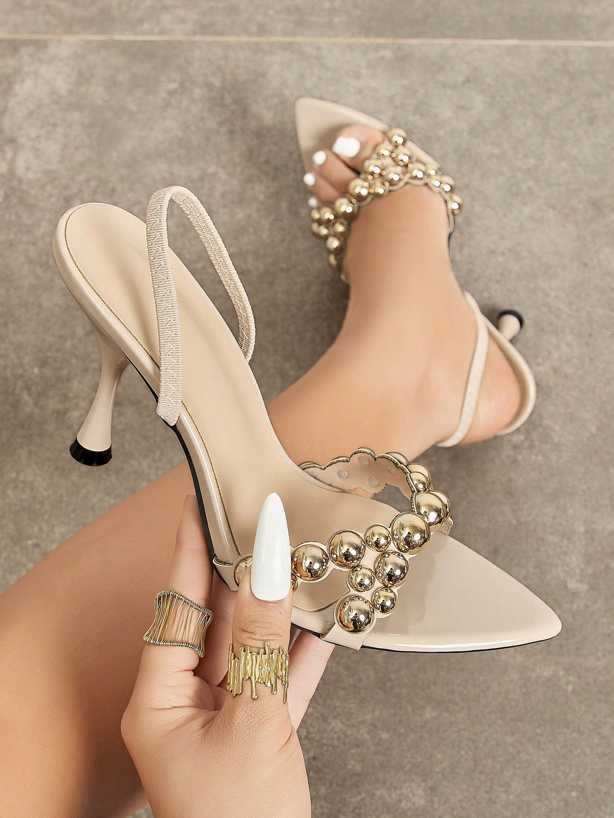 Pointed toe party high heels in gold featuring wavy lace trim, a stiletto heel, and back tie slingback straps.