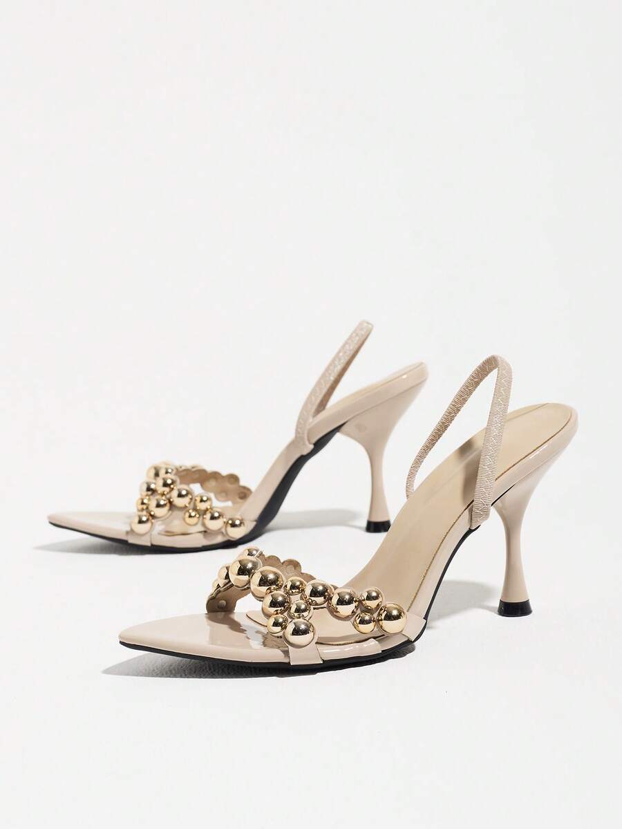 Pointed toe party high heels in gold featuring wavy lace trim, a stiletto heel, and back tie slingback straps.