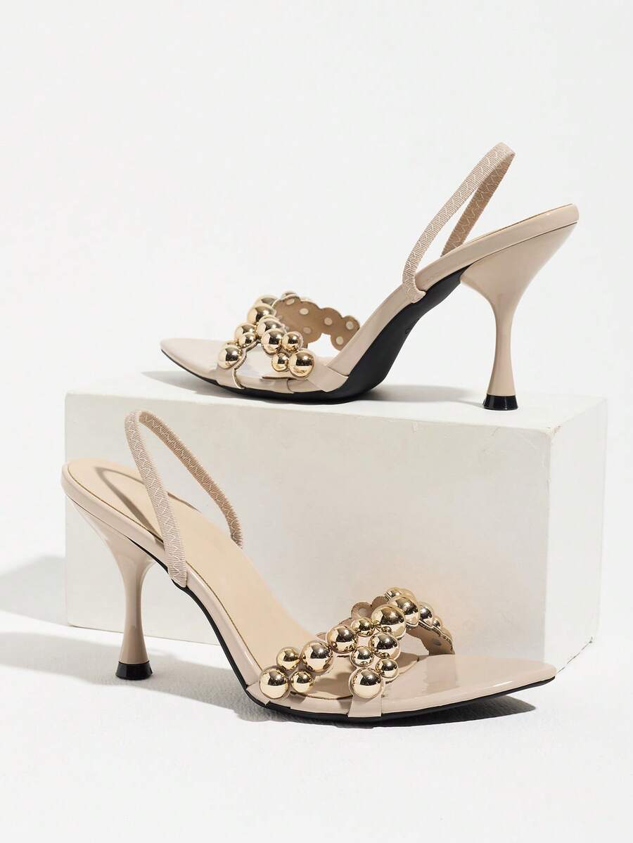 Pointed toe party high heels in gold featuring wavy lace trim, a stiletto heel, and back tie slingback straps.