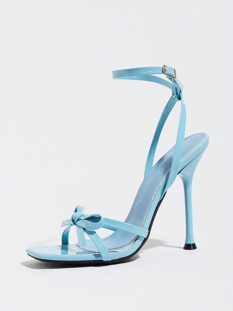Glossy high heel sandals with open round toe, stiletto heel, and cross ankle buckle strap