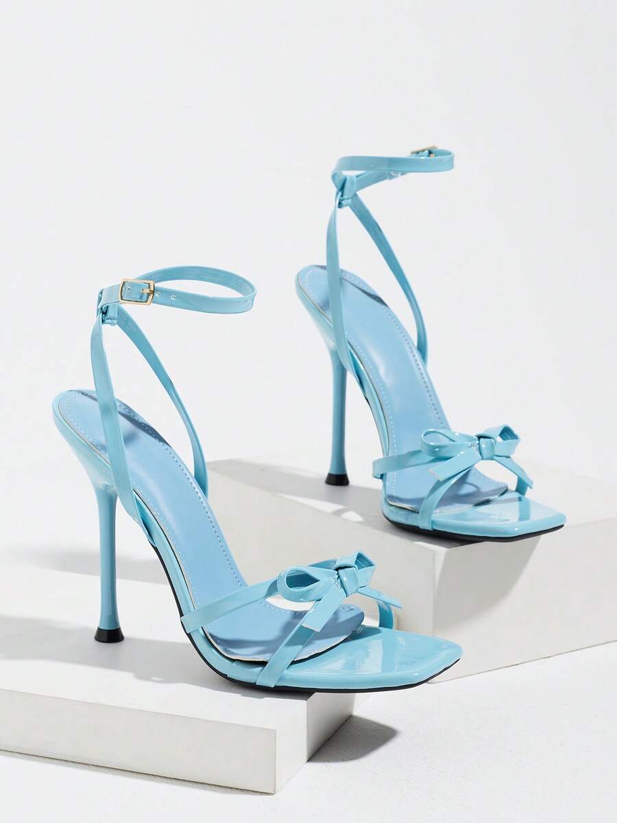 Glossy high heel sandals with open round toe, stiletto heel, and cross ankle buckle strap