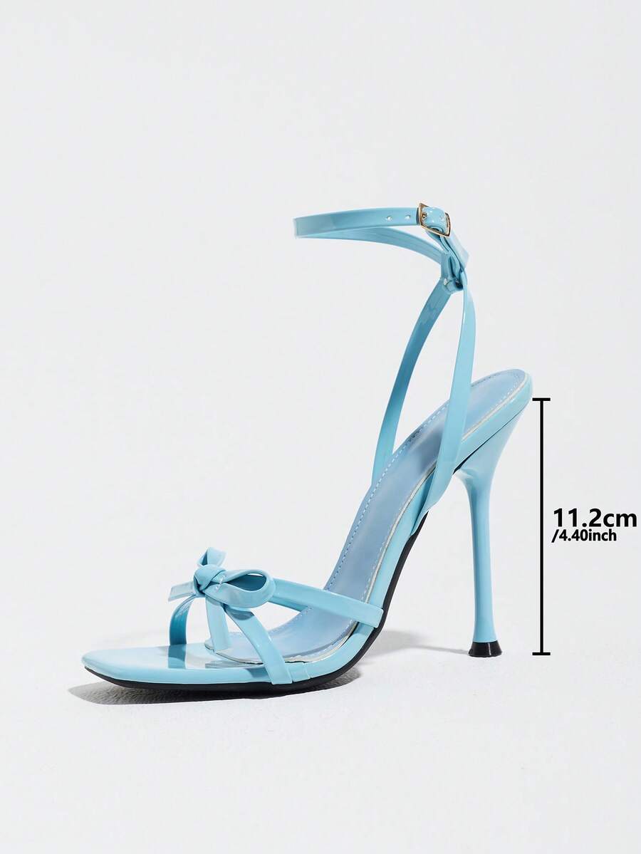 Glossy high heel sandals with open round toe, stiletto heel, and cross ankle buckle strap