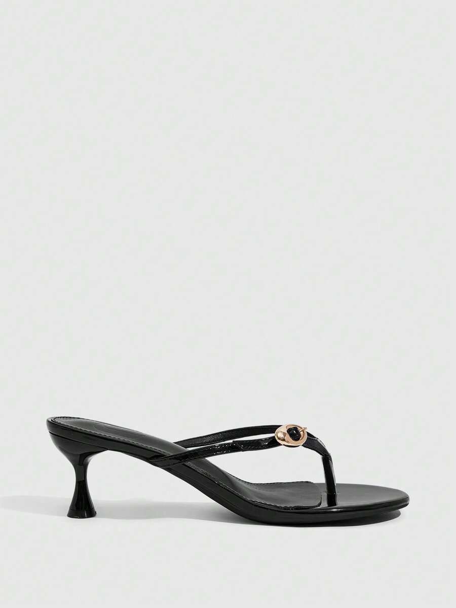 Women's slingback heeled sandals featuring a button toe post accent, sleek mid pyramid heel, and smooth faux leather finish.